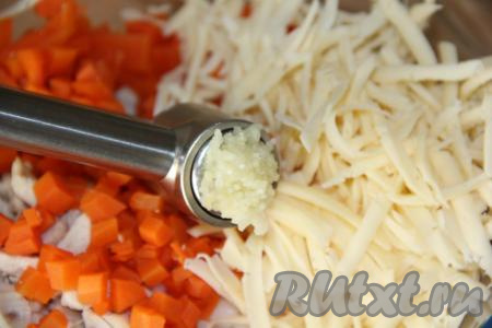 В салат из курицы, яиц и риса добавить сыр, морковь и зубчик чеснока, пропущенный через пресс.