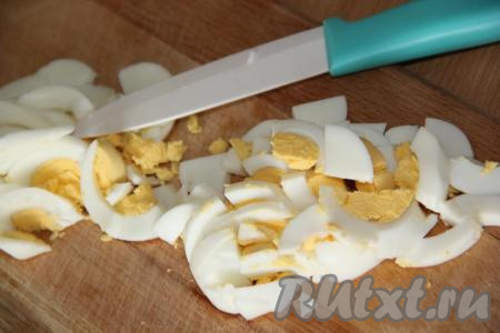 Сварить 2 яйца вкрутую (на варку потребуется около 10 минут с начала кипения воды). Варёные яйца, чтобы они остыли и хорошо чистились, залить холодной водой, а после остывания очистить и нарезать некрупно.