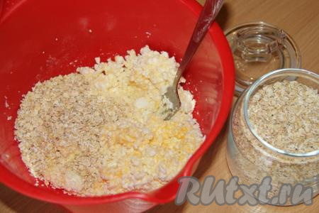 С помощью вилки перемешать массу. Всыпать овсяные хлопья и щепотку соли.