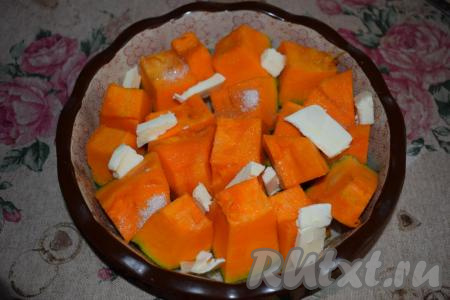 В форму (я взяла керамическую) выкладываем тыкву, посыпаем её сахаром и раскладываем между кусочками тыквы сливочное масло, нарезанное на пластины.