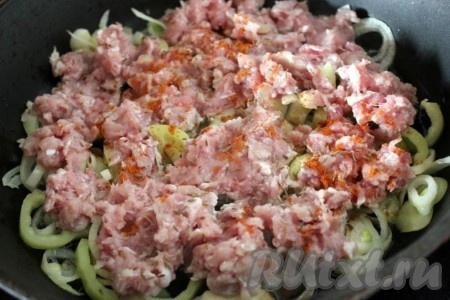Добавьте фарш и специи, посолите и обжарьте всё вместе на сильном огне минут 15.