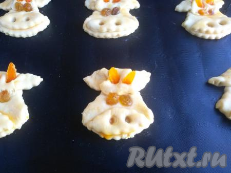 Заготовки печенья "Бычки" смазать взбитым яйцом, выложить на коврик для запекания (или на пекарскую бумагу), выпекать в разогретой духовке при температуре 190 градусов в течение 20 минут.