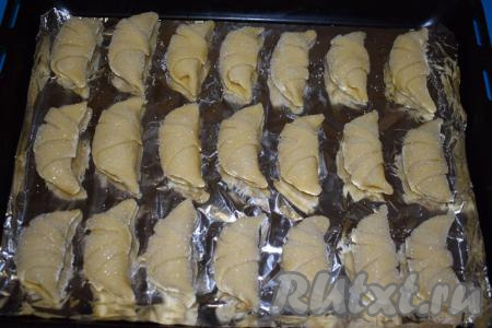 На противень, застеленный фольгой (или пергаментной бумагой), выкладываем обваленные рогалики, соблюдая расстояние, так как в духовке рогалики слегка увеличатся и распухнут.