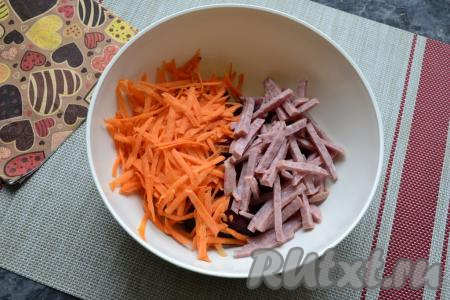 Очистить сырую морковь, а затем натереть на крупной тёрке. Колбасу нарезать брусочками (или соломкой) и вместе с морковкой выложить к свекле.
