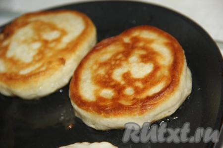 Жарить оладушки на среднем огне с двух сторон до золотистого цвета. Затем переложить на тарелку, а на той же сковороде аналогично пожарить оладьи из оставшегося теста.