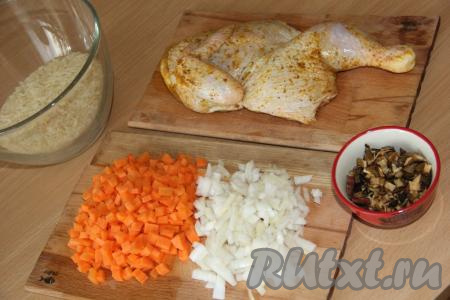 Куриное мясо вымыть. Я взяла половинку тушки, не разрезая её на части (можно, конечно, разрезать курицу на порционные кусочки). Курочку посолить со всех сторон и замариновать любым способом (я обмазала специями для птицы со всех сторон) и оставить пропитаться солью и специями минут на 30. Лук и морковь почистить. Морковку нарезать на кубики, а луковицу нарезать достаточно мелко. Сушёные грибы промыть под горячей водой, а затем измельчить ножницами. Если у вас нет грибов, то приготовить это блюдо можно и без них.