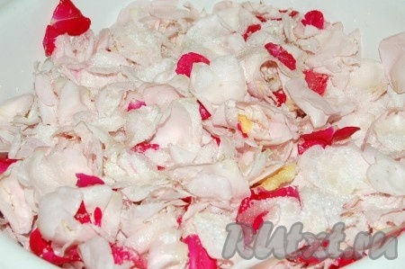 Затем собрать лепестки роз в таз, в котором будет вариться варенье и пересыпать их половиной количества сахара. Оставить на 6 часов, сверху прикрыть полотенцем.