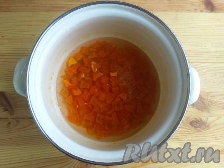 Тыкву вместе с выделившимся соком переложить в кастрюлю, поставить на минимальный огонь, довести до кипения и варить 5 минут на медленном огне, затем снять с огня. Оставить тыкву в сиропе на 12 часов.