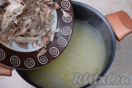 Затем извлеките кусочки курицы из бульона и переберите, отделяя мясо от костей. Бульон процедите, верните в него мясо и поставьте кастрюлю снова на огонь.