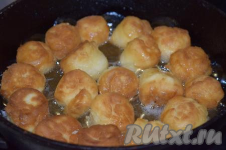 Жарим творожные пончики на умеренном огне с двух сторон, примерно, по 3-4 минуты, периодически поворачивая их в масле на сковороде со стороны на сторону для равномерной прожарки.