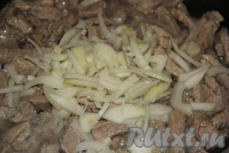 Лук почистить и нарезать полукольцами. Добавить лук в сковороду и обжарить вместе с мясом, не забывая иногда перемешивать, в течение 5 минут.