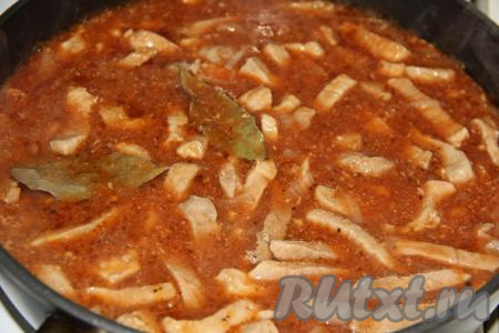 На сковороду с мясом, луком и томатной пастой влить стакан (200 мл) воды, перемешать, добавить лавровые листочки, дать закипеть. Затем тушить свинину в томатном соусе под крышкой на медленном огне в течение 45-50 минут.