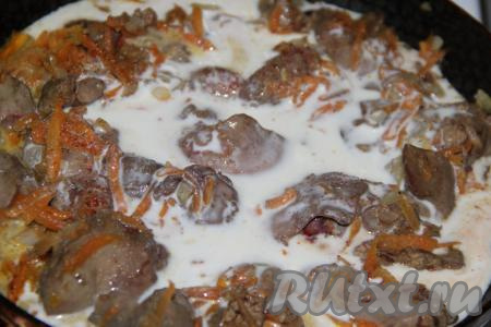 В сковороду с куриной печенью и овощами влить сметанный соус.