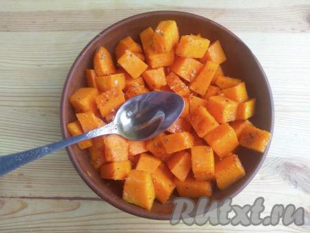 К кусочкам тыквы влить 2,5 столовых ложки растительного масла, перемешать и оставить на 20 минут при комнатной температуре для маринования.
