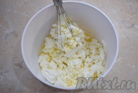 Затем выложите в чашу творог и и перемешайте всё с помощью венчика (или разомните вилкой до однородности). Творог выбирайте мягкий, если он сильно крупинчатый, то его необходимо протереть через сито, чтобы сделать его консистенцию более однородной.