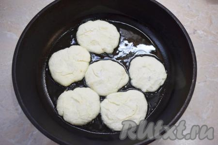 Выкладывайте подготовленные сырники на горячую сковороду и обжаривайте их с добавлением небольшого количества растительного масла до золотистости с двух сторон (примерно, по 1-2 минуте с каждой стороны).