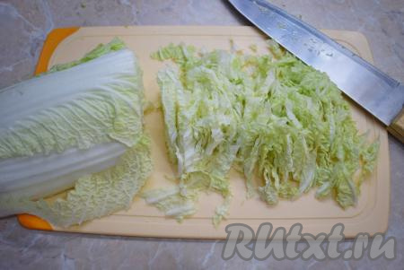 Пока курочка жарится, займитесь подготовкой овощей. С пекинской капусты снимите пару верхних листиков (они нам не понадобятся). Затем разрежьте кочан по всей длине и нашинкуйте.