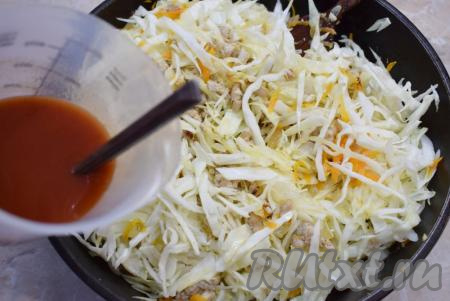 Добавьте капусту в сковороду. В стакане смешайте томатную пасту и 100 мл воды, вылейте на сковороду с капустой и фаршем, добавьте соль и специи по своему вкусу, перемешайте. Накройте сковороду крышкой, дайте томатному соусу закипеть, а затем тушите капусту с фаршем на небольшом огне, примерно, 20 минут (готовая капуста должна стать мягкой).