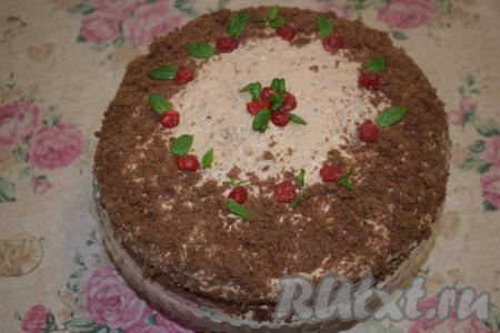 Начинаем украшать наш торт. Покрываем бока торта бисквитной крошкой. Также посыпаем верх торта шоколадной крошкой, не задевая центр. Вокруг не посыпанного крошкой участка раскладываем листочки мяты и сушёную вишню. В центре делаем цветочек из сушёной вишни, украшаем его мятой. Наш шоколадный торт с чиз кремом готов. Отправляем его в холодильник на 7-8 часов&nbsp;для пропитки.