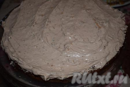 На блюдо, на котором будем собирать торт, кладём первый шоколадный корж и наносим на него слой чиз крема, накрываем вторым коржом, тоже смазываем кремом, сверху выкладываем третий корж. Верх торта и бока тоже покрываем кремом.