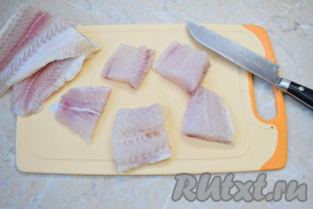 Затем нарежьте обсушенное филе пангасиуса на порционные кусочки.