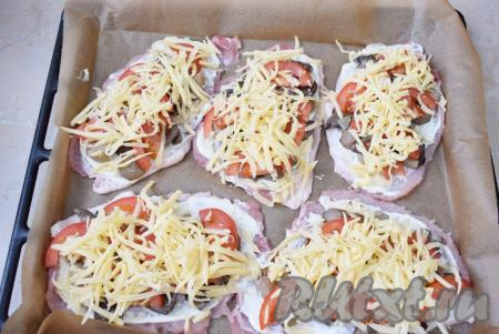 Сыр натрите на крупной тёрке и разложите его по всем отбивным. Поставьте противень в духовку, разогретую до 180 градусов, на 25-30 минут. Ориентируйтесь по своей духовке. Готовые отбивные станут румяными, сыр расплавится и будет слегка золотистого цвета.