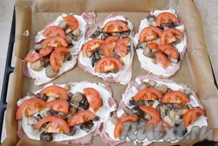 Помидоры разрежьте на две части, а затем нарежьте на тонкие ломтики. Разложите нарезанные помидоры поверх грибов, сверху немного посыпьте солью и специями.