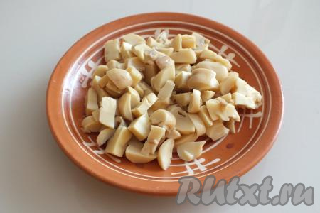 Нарежьте на небольшие кусочки 100 грамм консервированных шампиньонов. Для приготовления салата "Афродита" желательно, чтобы грибы, колбаса, яйца и сыр были нарезаны на кубики, примерно, равного размера.