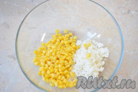 Когда рис остынет, выложите его в достаточно объёмную миску, в которой будете готовить салат. Из банки с консервированной кукурузой слейте жидкость. Выложите кукурузу к рису.