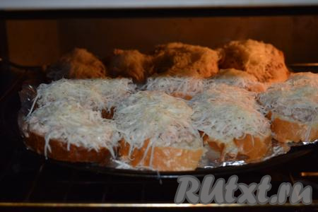 Отправляем противень с бутербродами в разогретую духовку и запекаем при температуре 180 градусов в течение 15-18 минут.