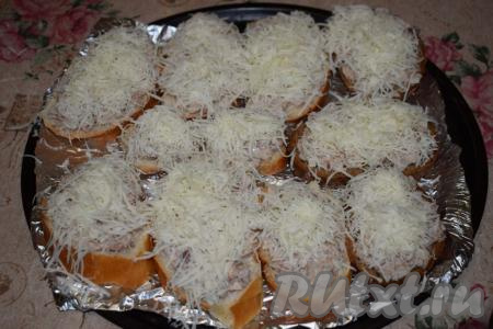 Каждый бутерброд с рыбными консервами обильно посыпаем сыром, натёртым на средней тёрке.