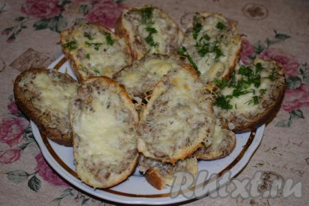 Готовые бутерброды с рыбными консервами достаём из духовки, перекладываем их на блюдо и посыпаем сверху мелко нарезанной зеленью и измельчённым зелёным луком.