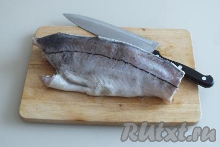 Заранее размороженную пикшу вымойте, вычистите брюшко, рыбку очистите от чешуи.