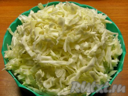 С капусты снимаем верхние и испорченные листья, споласкиваем её тёплой водой и просушиваем бумажным полотенцем. Пока вы не начали резать капусту, снимите с неё несколько чистых крупных листьев - они нам пригодятся немного позже. Нарезаем капусту достаточно тонкими полосочками, примерно, по 5 мм толщиной.