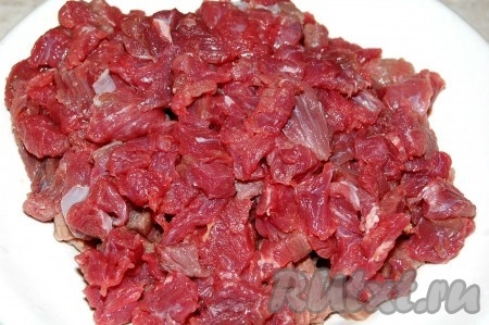 Мясо нарезать мелкими кусочками и опустить обжариваться в казан.