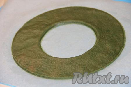 Из этого же теста приготовить кольцо, размер выбирайте сами, у меня диаметр 25 см. Я подкрасила небольшое количество теста зелёным гелевым красителем. Ровное кольцо можно вырезать, используя тарелки разного размера. Я из указанного количества ингредиентов сделала 3 венка, соответственно и вырезала 3 кольца.