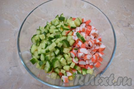 Крабовые палочки освободите от плёнок и нарежьте вместе с огурцами небольшими кубиками, выложите в салатник.