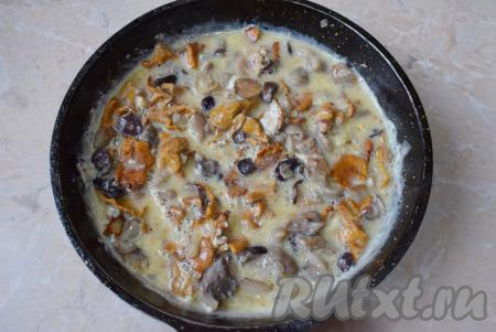 Залейте яичной смесью грибы с луком и сразу перемешайте содержимое сковороды.