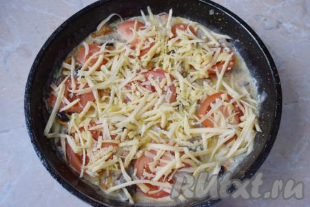 Верх омлета&nbsp;с грибами и помидорами посыпьте сыром, натёртым на тёрке. Накройте сковороду крышкой, сделайте маленький огонь и готовьте 5-6 минут.