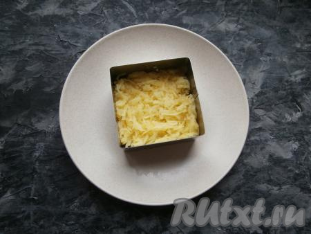 Смазать шпроты майонезом. Вторым слоем выложить натёртый на мелкой тёрке картофель, немного его посолить.