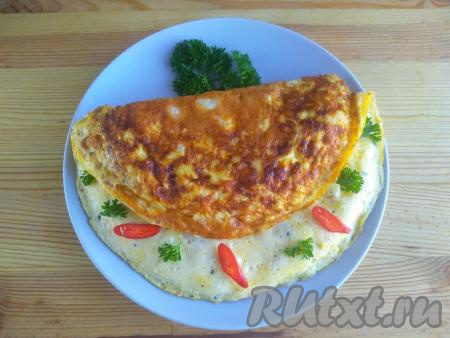 Готовый омлет с цветной капустой переложить со сковороды на тарелку, украсить зеленью, кусочками перца&nbsp;чили (по желанию) и подать к столу.