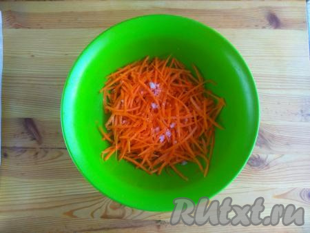 Морковь очистить от кожуры, натереть на тёрке для корейской моркови, выложить в миску, добавить соль и сахар.