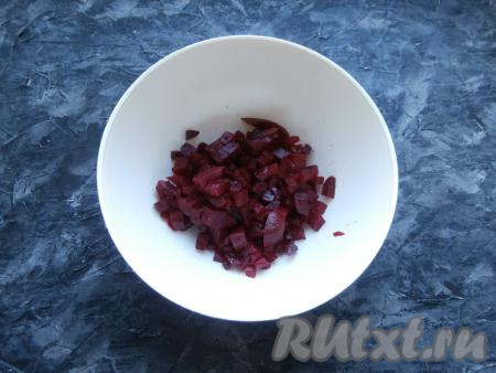 Предварительно нужно отварить свеклу в кожуре (в течение минут 45-50 с начала кипения воды) и картофель в кожуре (на его варку потребуется 25-30 минут с момента закипания воды), остудить сварившиеся овощи и очистить. Свеклу нарезать небольшими кубиками и выложить в миску.