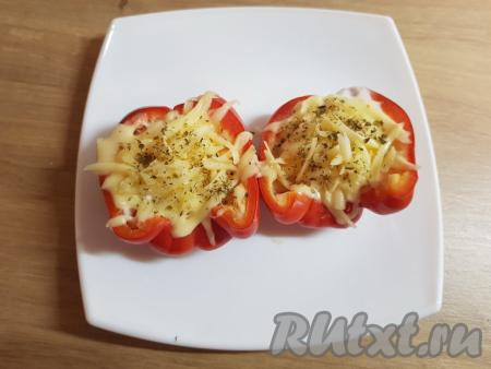 Тарелку с перцами поставить в микроволновку и готовить при мощности 800 Вт 2,5 минуты. По прошествии времени достать перцы из микроволновки, сверху посыпать яйца натёртым сыром и сушёным орегано. Затем снова поставить перцы в микроволновку на 30 секунд.