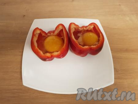 Затем аккуратно вбить в каждую половинку перца по сырому яйцу. Далее яйца посолить по вкусу.