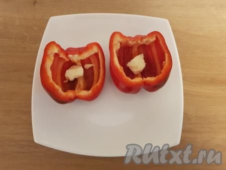 Болгарский перец разрезать на 2 части, удалить семена и плодоножку, поместить на тарелку, пригодную для микроволновки. В каждую половинку перца добавить по 1/2 чайной ложки сливочного масла.