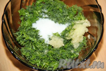 Зелень мелко нарезать. Зубчики чеснока почистить и пропустить через пресс. Соединить зелень, чеснок и соль.
