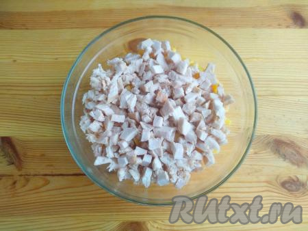 Филе курицы выложить в кастрюлю, залить мясо водой, отправить на огонь, а после закипания варить в течение 25-30 минут на небольшом огне. Готовое отваренное филе, сняв с огня, остудить в бульоне. Нарезать мясо небольшими кубиками, добавить к ананасам, сыру и яйцам.