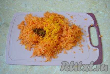 Для приготовления бисквита вымойте морковь, очистите её от кожуры, а затем натрите на мелкой (или средней) тёрке. Апельсин тщательно вымойте, снимите с него цедру, не затрагивая белый слой, находящийся под цедрой. 150 грамм натёртой моркови выложите в миску, добавьте 1 столовую ложку апельсиновой цедры и 0,5 чайной ложки корицы, перемешайте.