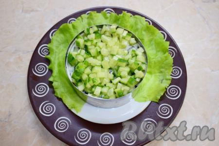 Свежий огурец нарежьте мелкими кубиками и выложите следующим слоем салата, нанесите майонез.